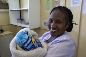 Nurse Patricia while holding a few hours old baby at labour ward of New Masala Health Centre in Zambia