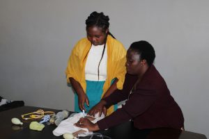 Mary-Msika-in-yellow-scarf-being-trained-by-Sylvia-Kandiyera-on-how-to-resuscitate-neonates-and-young-infants-with-respiratory-and-cardiorespiratory-conditions